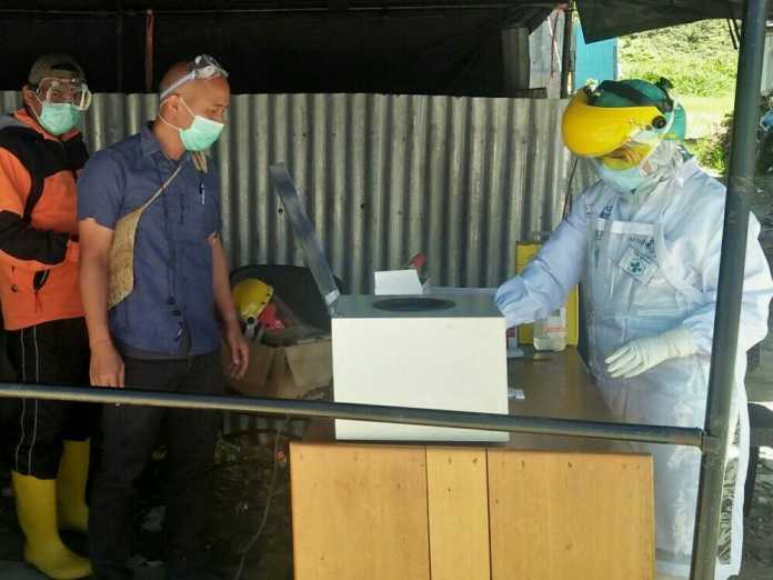 Dokter Laswan (tengah, pakai masker putih) usai di wawancara suarapapua.com hari ini, Rabu (6/5/2020), di posco penanganan Covid-19 kabupaten Paniai, Madi. (Stevanus Yogi - SP)